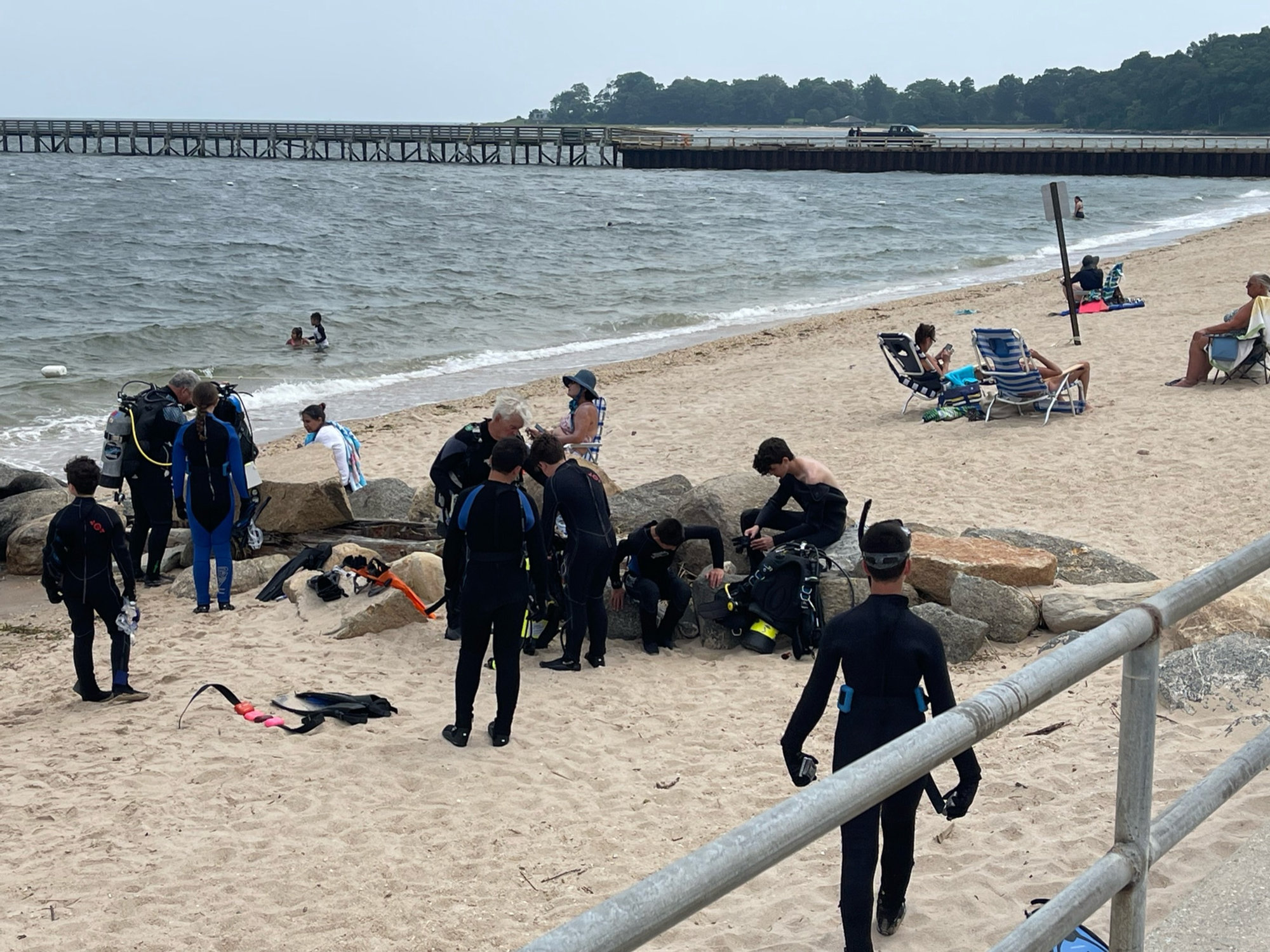 Divers entering the water from a Long Island beach